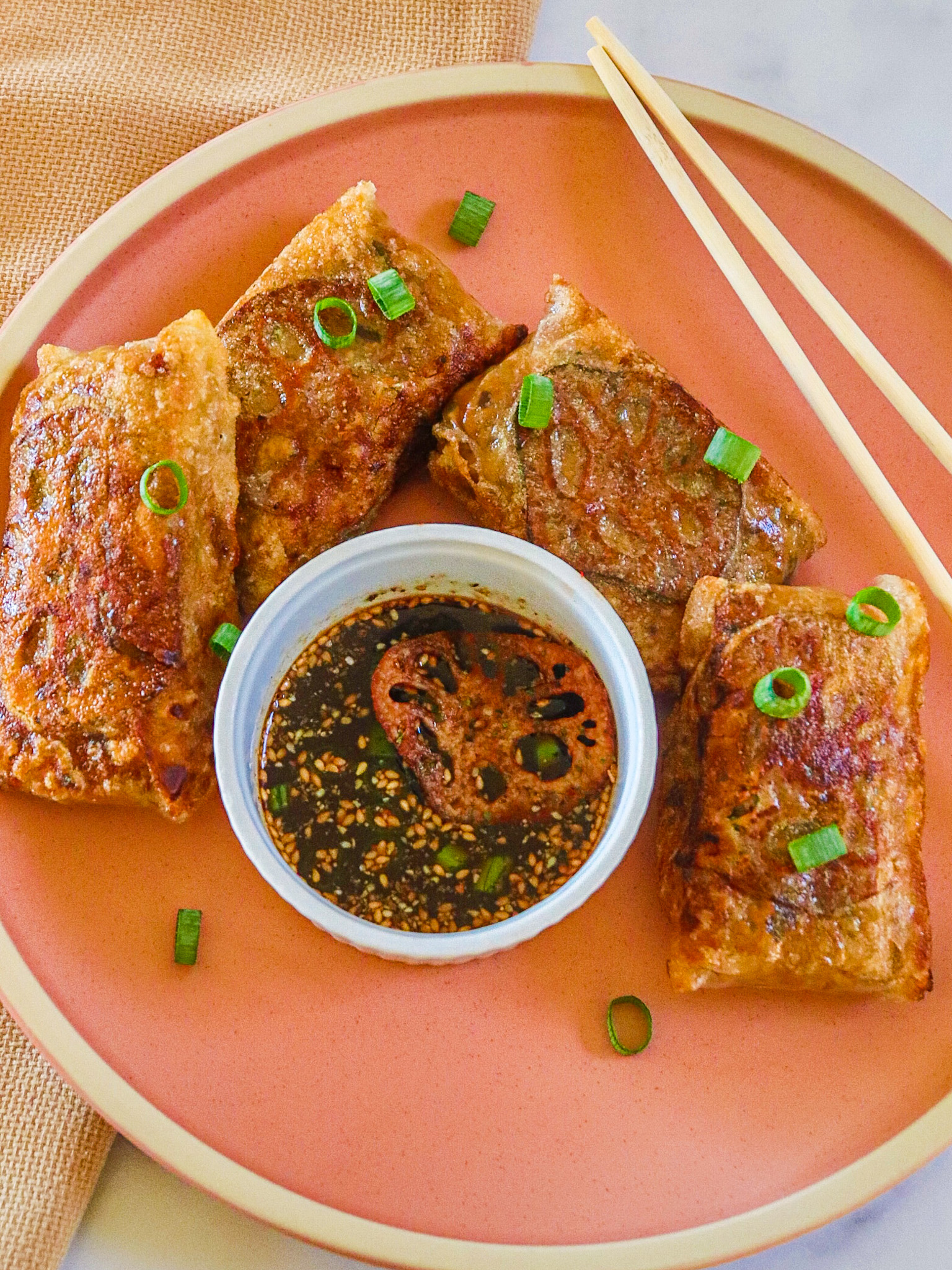 crispy rice paper dumplings with lotus root chips, scallions and coconut aminos sauce